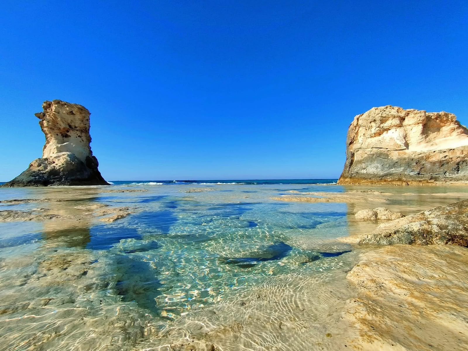 Crystal clear rock pools with ancient limestone formations, Matahani North Coast